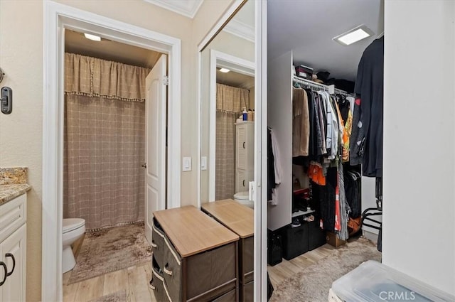 bathroom featuring hardwood / wood-style flooring, vanity, ornamental molding, a shower with curtain, and toilet