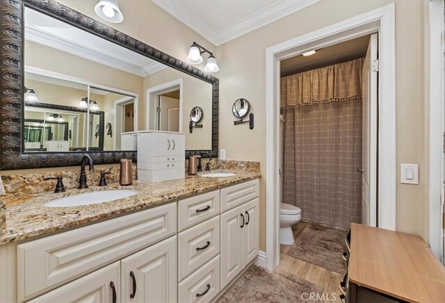 bathroom featuring toilet, a shower with curtain, ornamental molding, vanity, and hardwood / wood-style floors