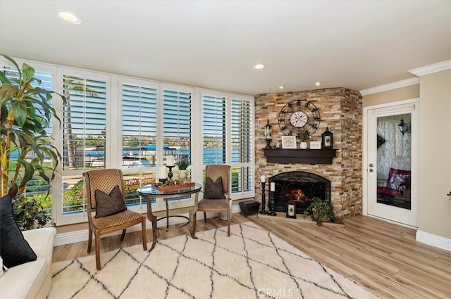 sitting room with crown molding, a fireplace, and light hardwood / wood-style floors