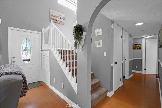 foyer entrance with a textured ceiling and wood-type flooring