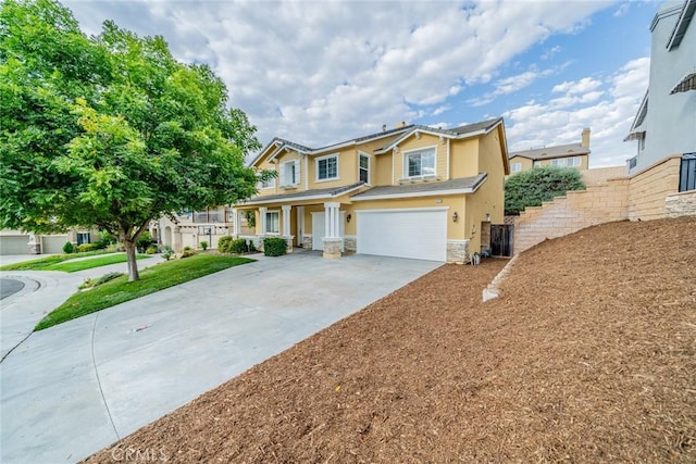 view of front of property with an attached garage, stone siding, concrete driveway, and stucco siding