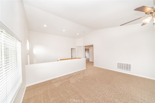 carpeted spare room featuring ceiling fan and vaulted ceiling