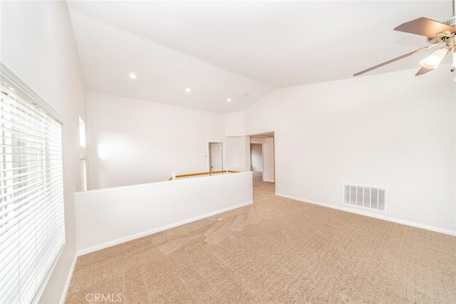 empty room featuring lofted ceiling, baseboards, visible vents, and carpet flooring