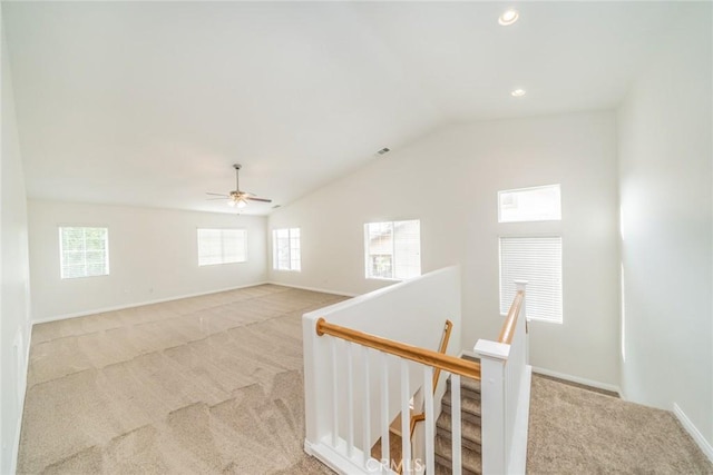 spare room featuring vaulted ceiling, recessed lighting, baseboards, and light colored carpet