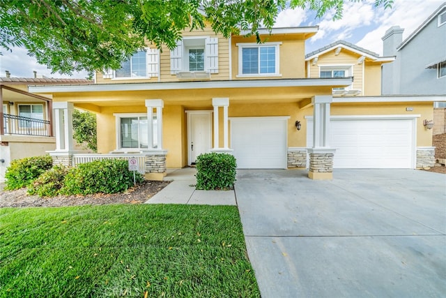 view of front of property with a porch, a front yard, and a garage