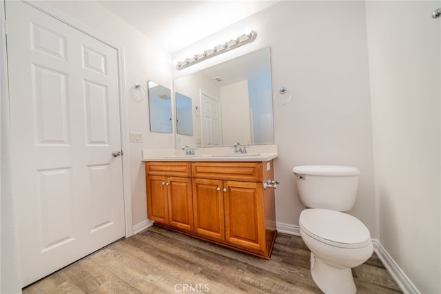 bathroom with vanity, toilet, and hardwood / wood-style floors