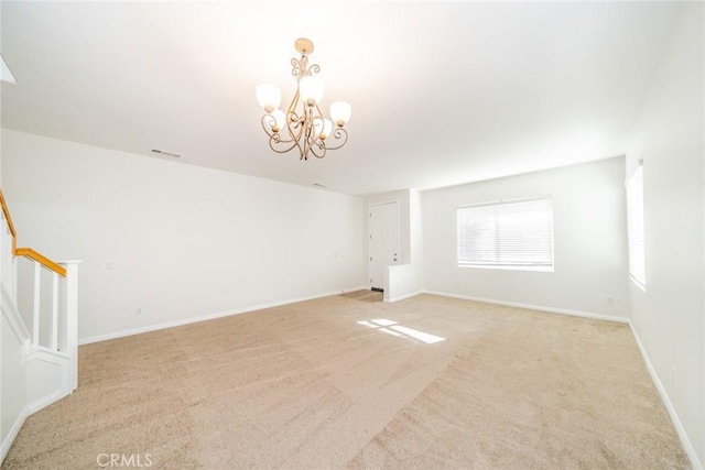 empty room featuring stairs, baseboards, a chandelier, and light colored carpet