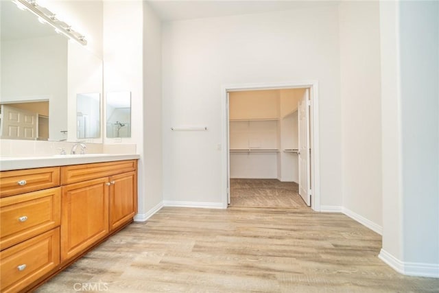 bathroom featuring vanity, baseboards, and wood finished floors