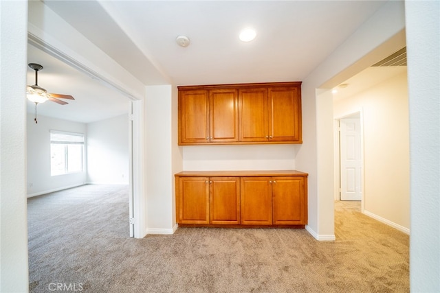 kitchen with light colored carpet and ceiling fan