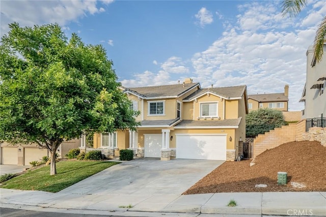 view of front of property featuring driveway, a garage, stone siding, fence, and stucco siding