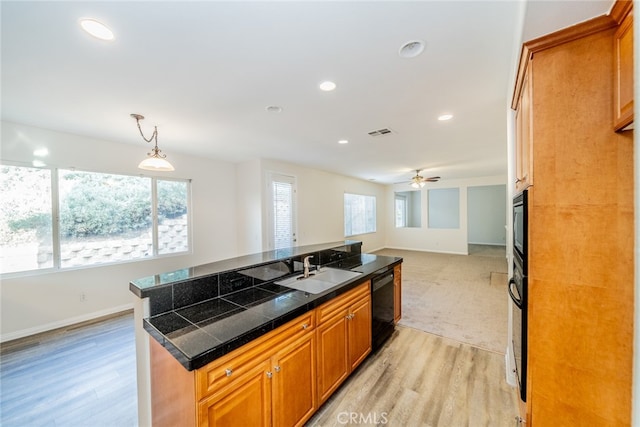 kitchen with sink, dishwasher, light hardwood / wood-style floors, ceiling fan, and decorative light fixtures