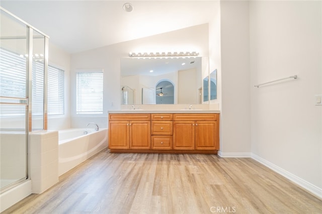 bathroom with vanity, lofted ceiling, hardwood / wood-style flooring, and independent shower and bath