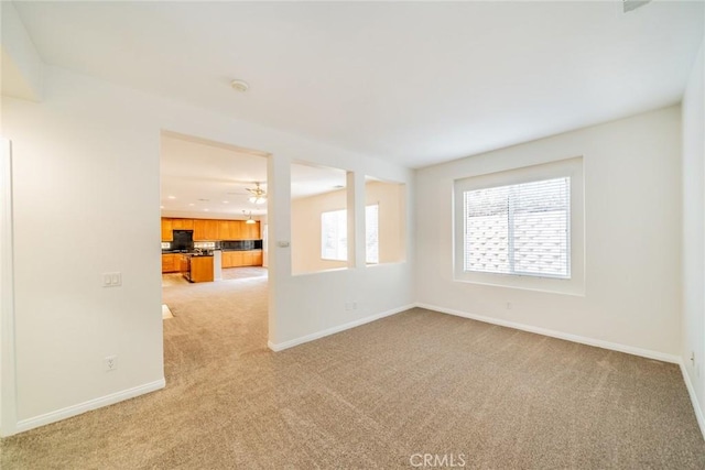 unfurnished room with light carpet and baseboards