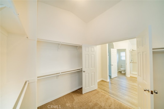 walk in closet featuring vaulted ceiling and light wood-type flooring