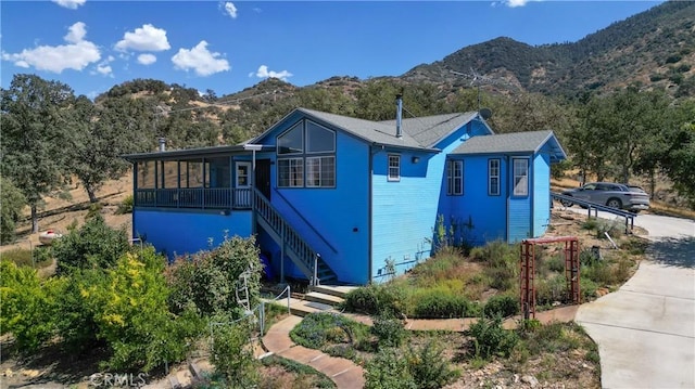 view of front of house featuring a mountain view and a sunroom