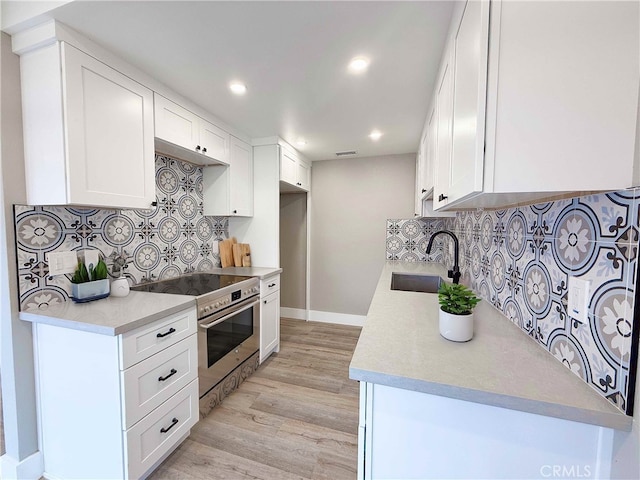 31377 Los Rios St Unit 64F, San Juan Capistrano, CA 92675 - kitchen featuring stainless steel stove, tasteful backsplash, light wood-type flooring, and a sink