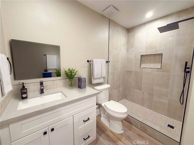 31377 Los Rios St Unit 64F, San Juan Capistrano, CA 92675 - bathroom featuring toilet, a tile shower, vanity, wood finished floors, and tasteful backsplash
