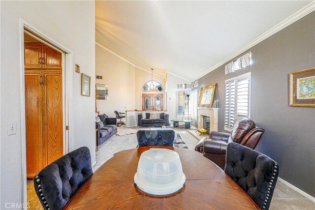 dining area featuring carpet floors, crown molding, and lofted ceiling