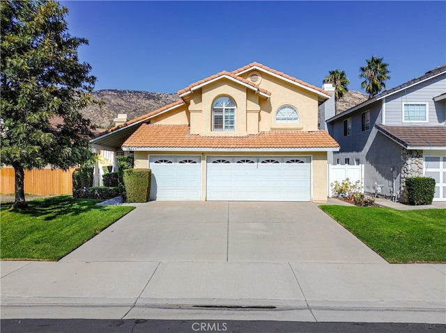 view of front of house with a mountain view, a garage, and a front lawn