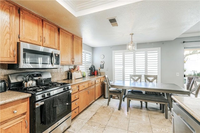 kitchen featuring stainless steel appliances, crown molding, a chandelier, pendant lighting, and a textured ceiling