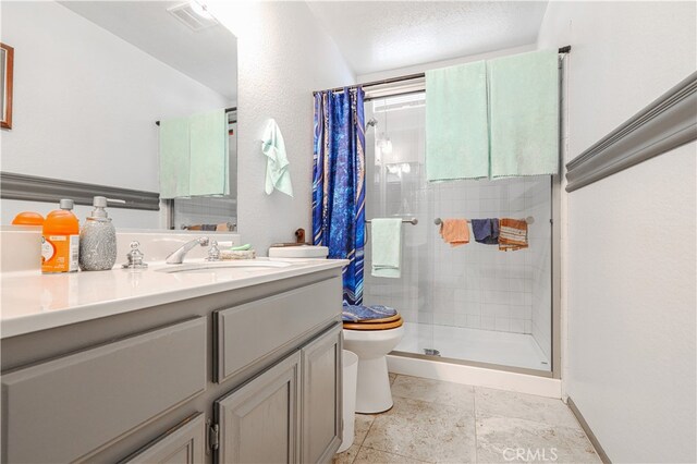 bathroom featuring vanity, toilet, and a shower with door