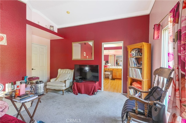 living area featuring hardwood / wood-style floors and crown molding