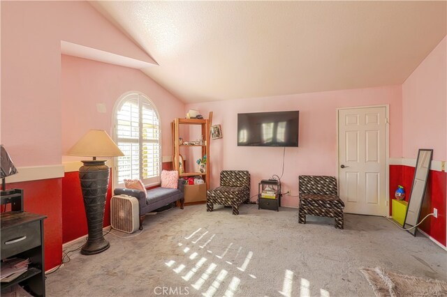 sitting room featuring a textured ceiling, lofted ceiling, and carpet floors