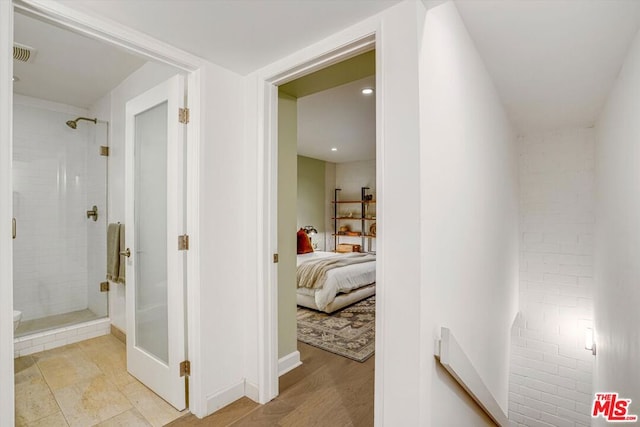 bathroom featuring hardwood / wood-style flooring and a shower with door