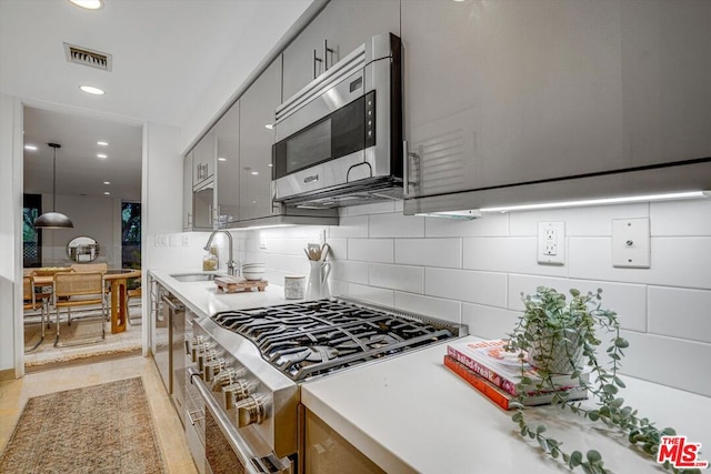 kitchen with decorative backsplash, stainless steel appliances, sink, gray cabinets, and light tile patterned flooring