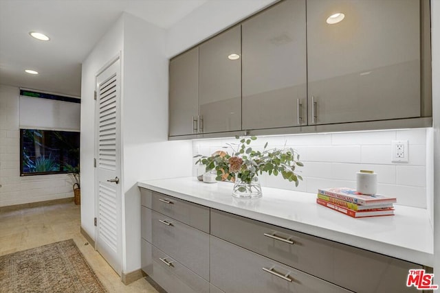 kitchen with backsplash, gray cabinets, and light tile patterned floors