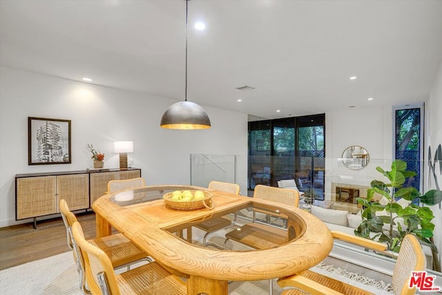 dining space with hardwood / wood-style floors and a wall of windows