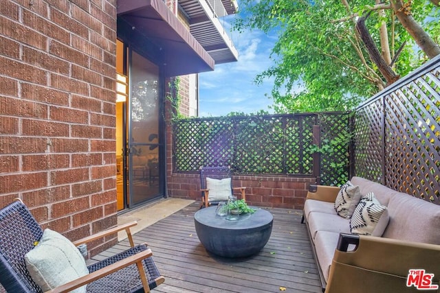 wooden terrace with an outdoor living space