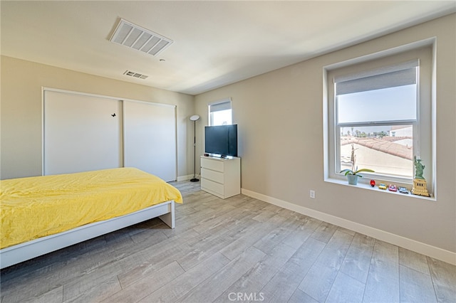 unfurnished bedroom with light hardwood / wood-style floors and a closet