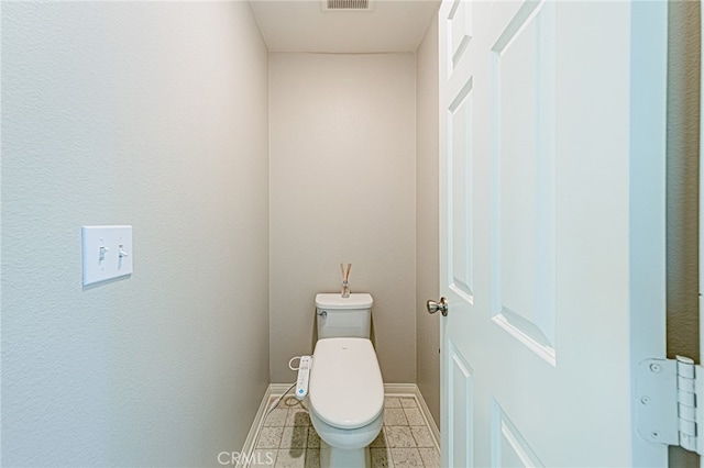 bathroom with toilet and tile patterned floors