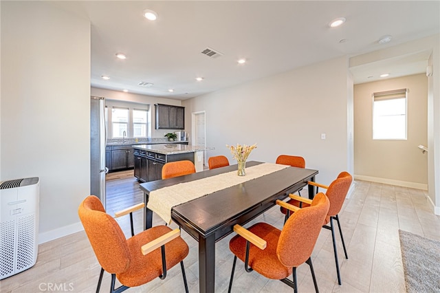 dining area featuring light wood-type flooring and sink