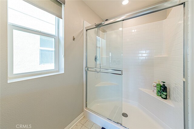 bathroom featuring a shower with door and tile patterned floors