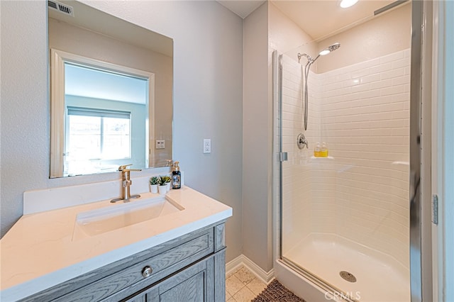 bathroom with tile patterned flooring, a shower with door, and vanity