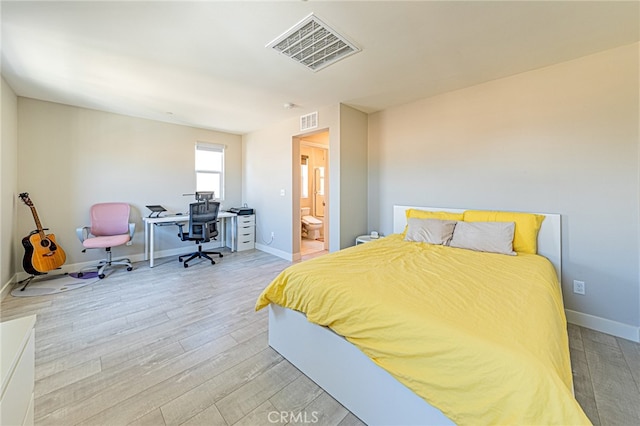 bedroom featuring light hardwood / wood-style flooring and ensuite bath