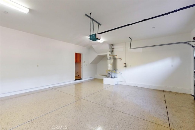 garage featuring strapped water heater and a garage door opener