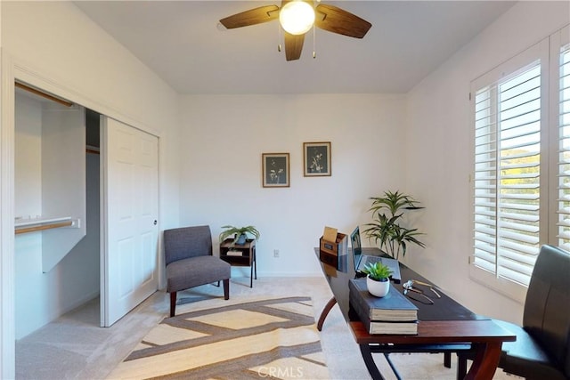 carpeted office featuring ceiling fan