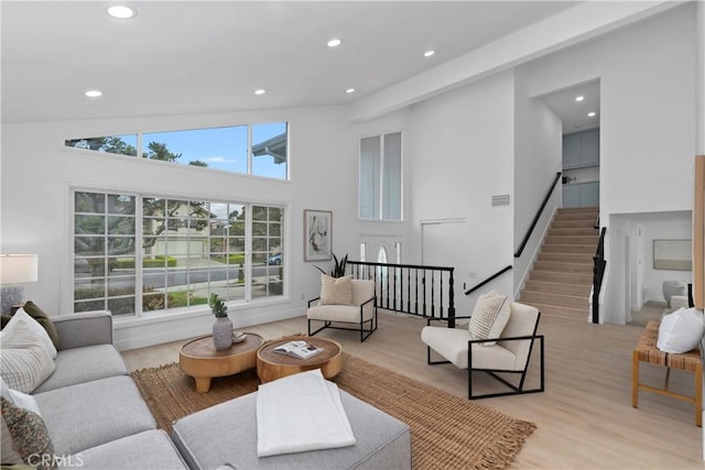 living room featuring stairway, recessed lighting, visible vents, and light wood finished floors