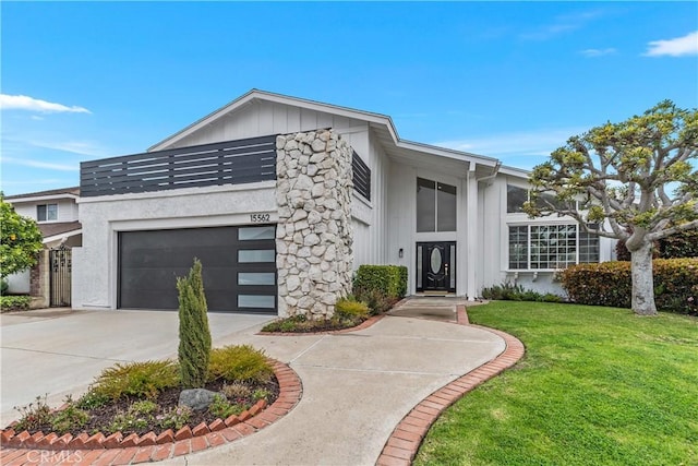 view of front of house with a front lawn, an attached garage, board and batten siding, and driveway