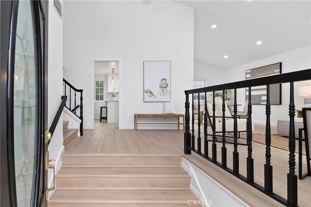 15562 Placid Cir, Huntington Beach, CA 92647 - stairs with recessed lighting, baseboards, high vaulted ceiling, and wood finished floors