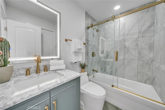 full bathroom featuring vanity, bath / shower combo with glass door, and toilet