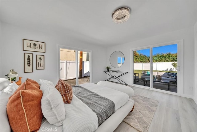 bedroom featuring access to exterior and light hardwood / wood-style flooring