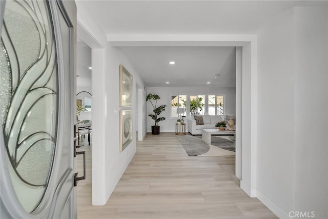 corridor featuring washer / clothes dryer and light hardwood / wood-style floors