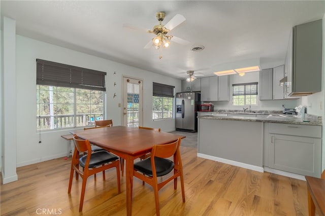 dining area featuring light hardwood / wood-style floors, sink, and ceiling fan