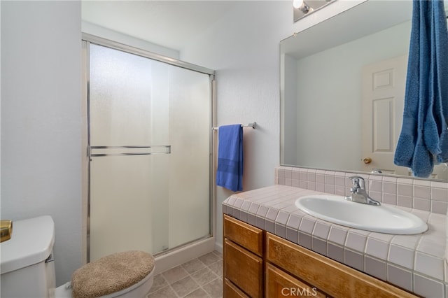 bathroom with vanity, a shower with shower door, and toilet