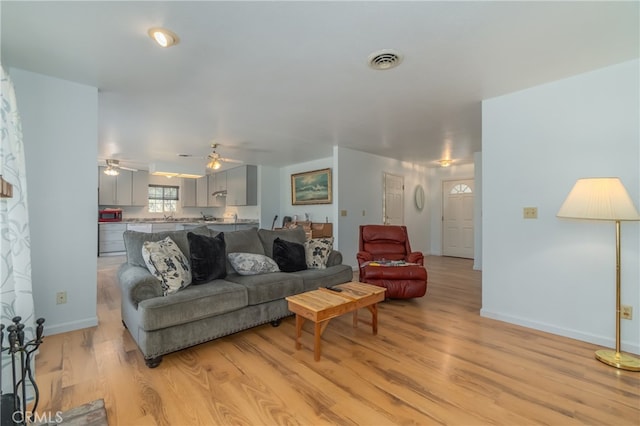 living room with ceiling fan and light hardwood / wood-style floors