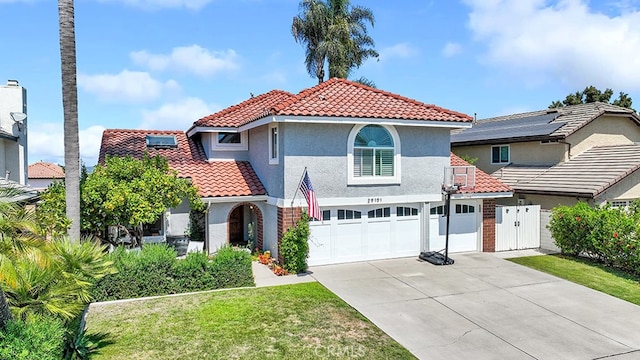 mediterranean / spanish home featuring a front yard and a garage